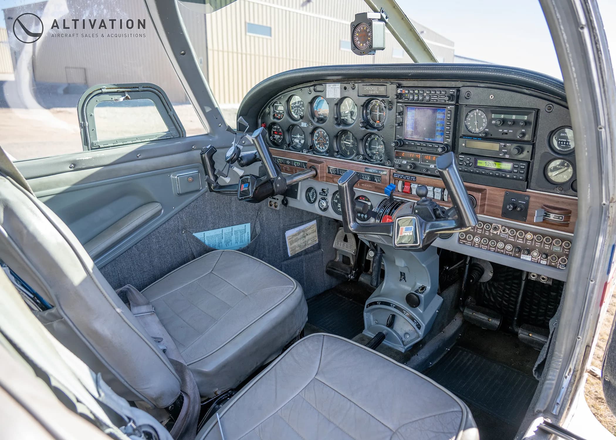 A view of the Piper Cherokee cockpit from the passenger side, showing the instrument panel and controls.