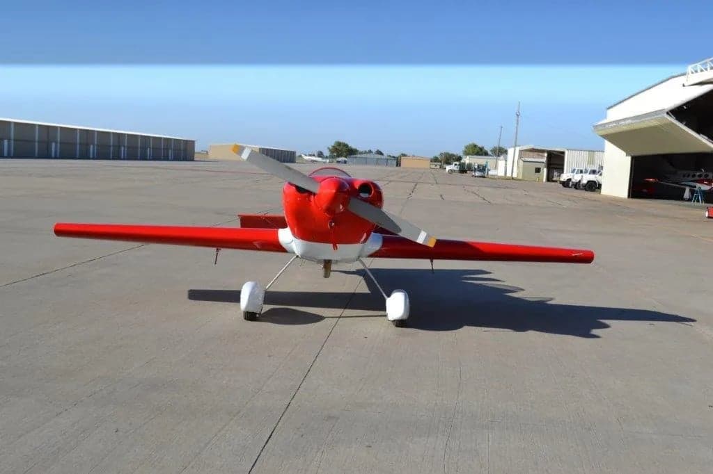 Front view of a red and white aircraft with stars on the tail and wings parked on the tarmac.