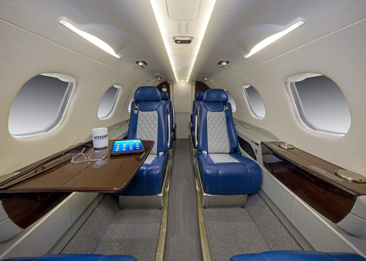 The interior of the aircraft, featuring blue and white seats and a table.