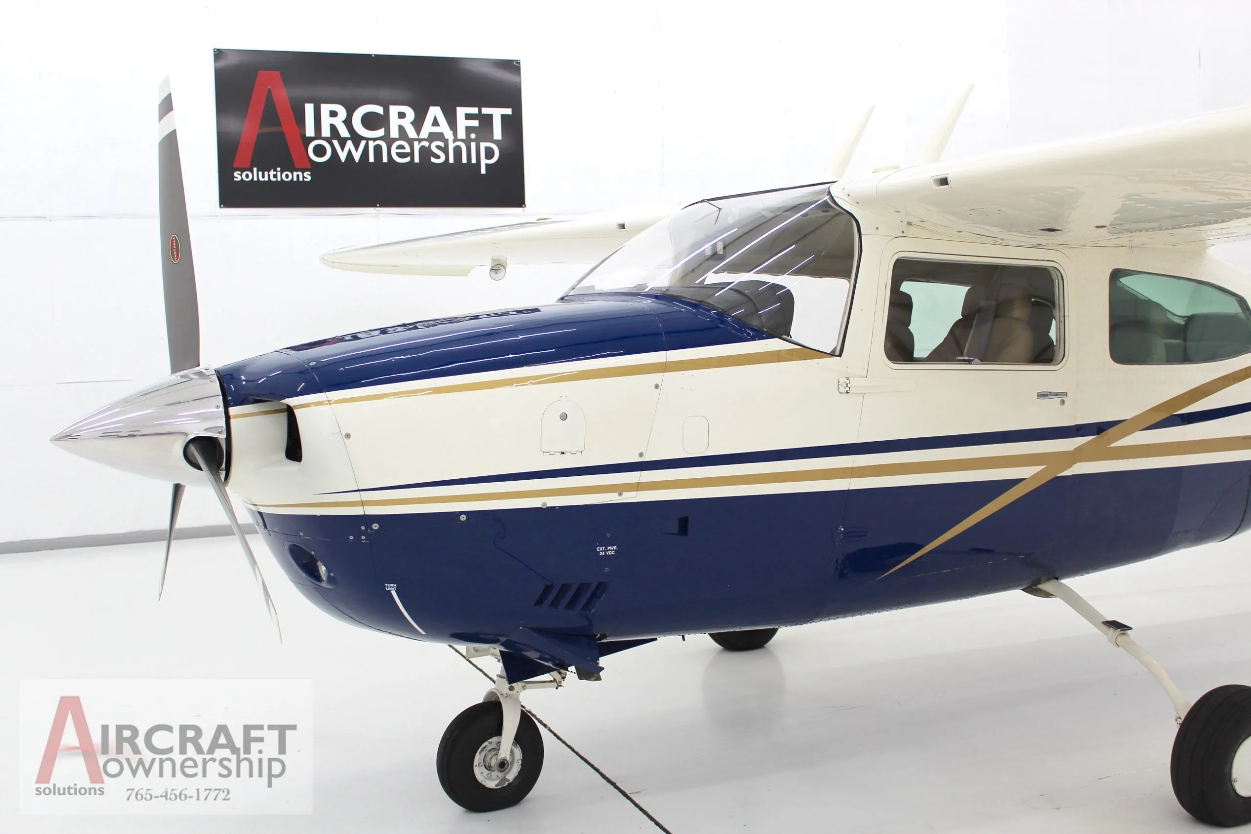Front view of a blue and white Cessna 206 aircraft, N5091V, showing the propeller and nose.