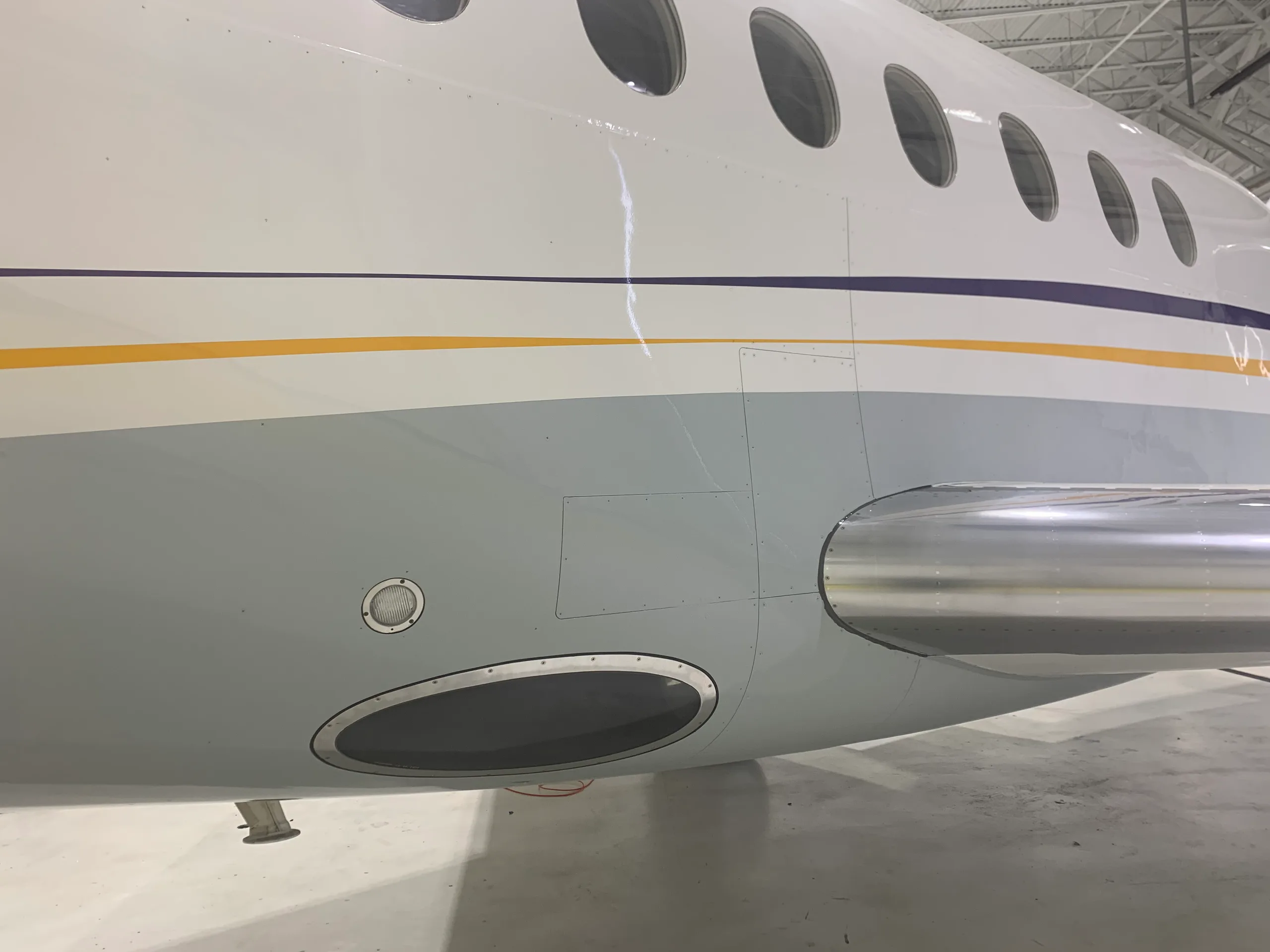 Close-up of the aircraft's fuselage, showing the windows and gray lower section.