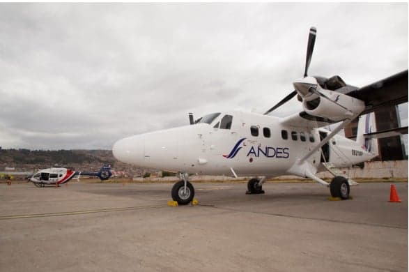 A Twin Otter aircraft with Andes livery parked on the tarmac.
