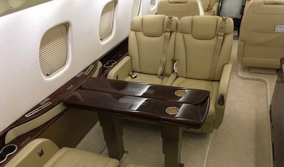 Interior of the aircraft featuring leather seats and a table.