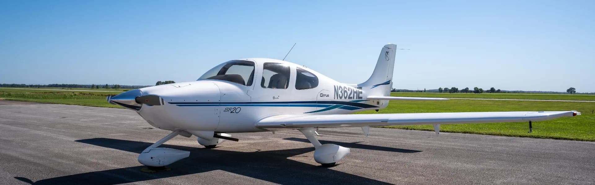 A Cirrus SR20 aircraft is parked on the tarmac.