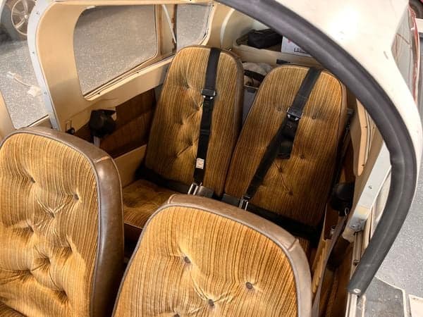 View of the aircraft's brown upholstered seats in the cabin.