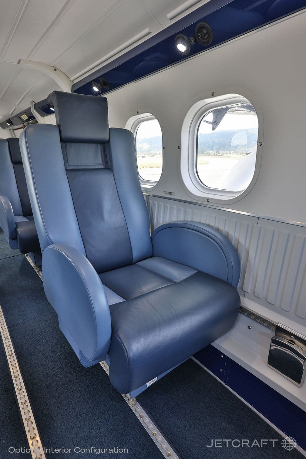 Close-up of a blue leather aircraft seat with a headrest.
