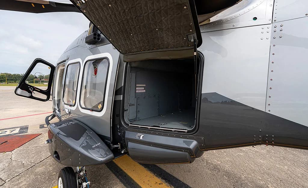 Side view of the AgustaWestland AW169 helicopter showing an open cargo compartment door and the main cabin door.