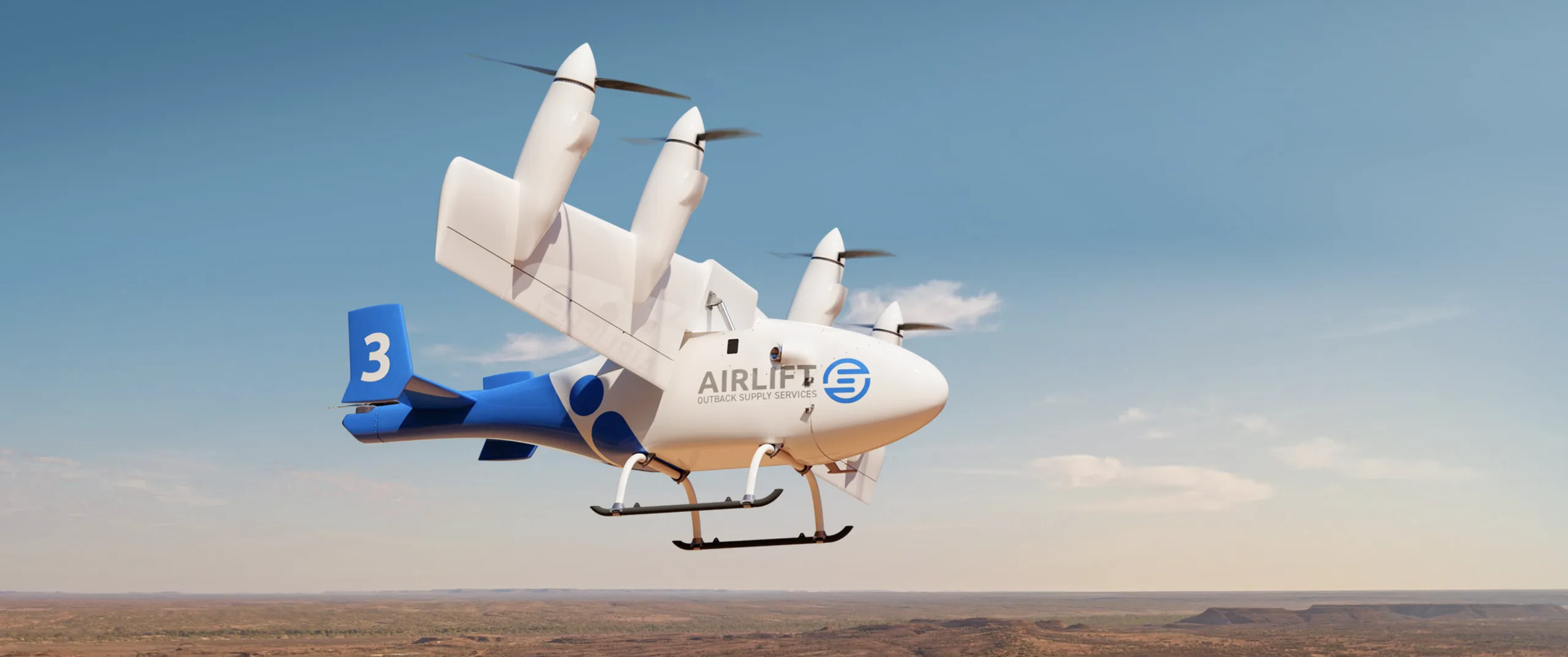 A blue and white Airlift eVTOL aircraft flying over a dry, rocky desert landscape.