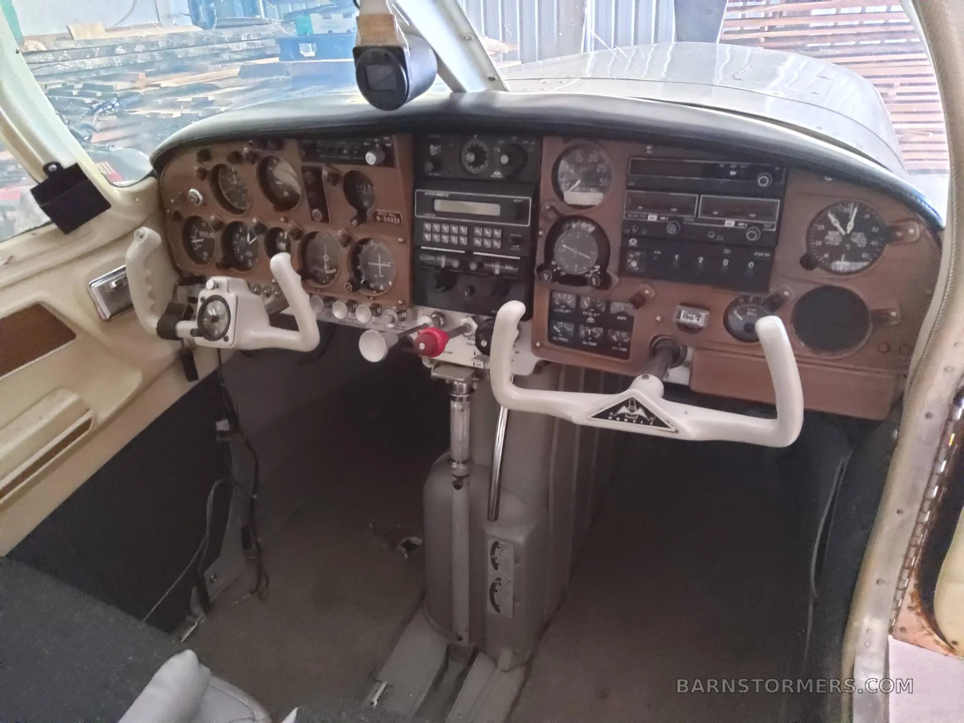 View of the cockpit with a brown instrument panel, dual yokes, and various gauges.