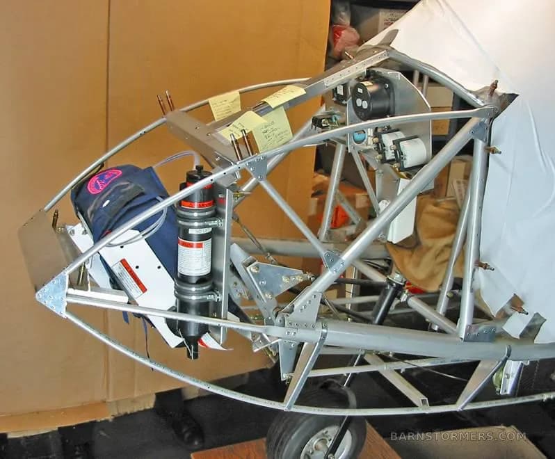 The front section of an ultralight aircraft frame, showing the nose wheel and a ballistic parachute system.