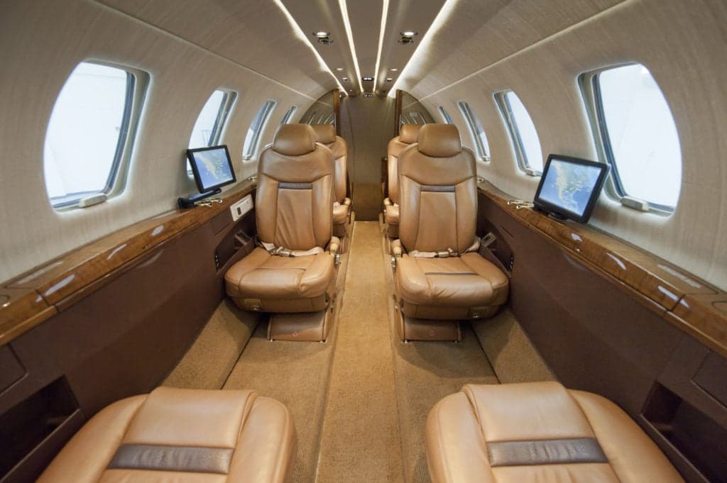 The interior of a Citation CJ4 aircraft with brown leather seats.