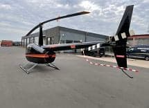 Rear view of a Robinson R44 Raven II helicopter on the tarmac.