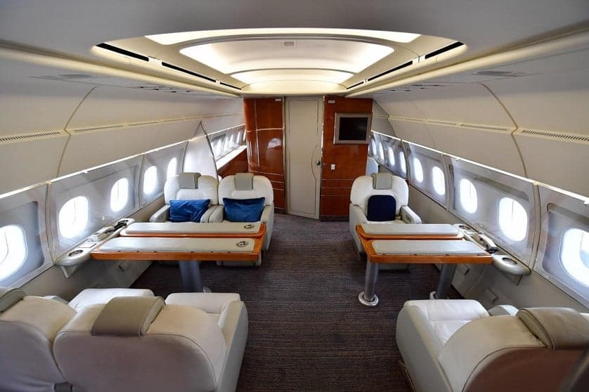 Interior of the aircraft with white seats and tables.