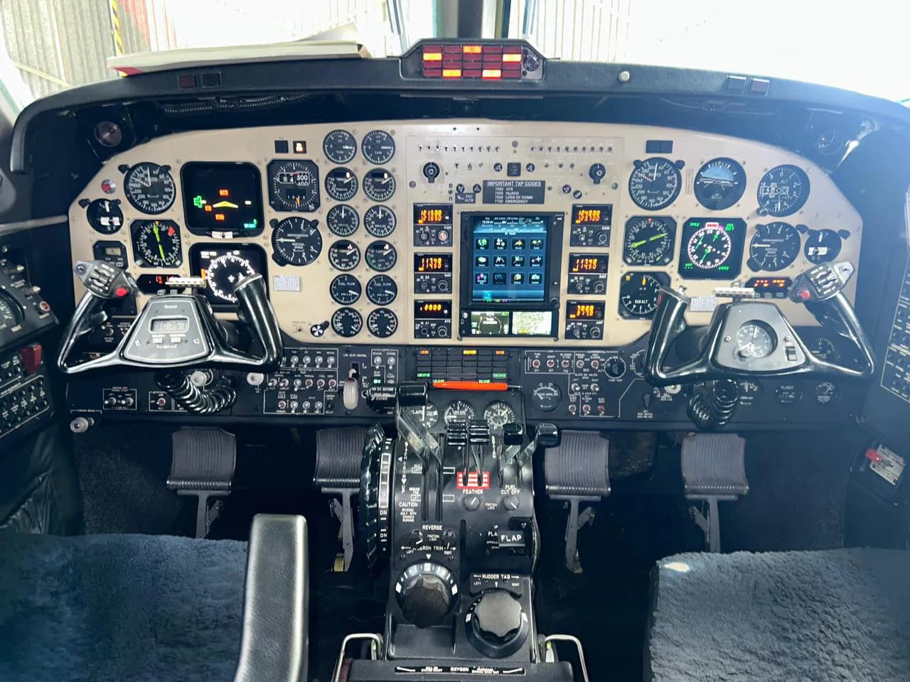 The cockpit of a Beechcraft King Air aircraft features a mix of analog gauges and modern digital displays.