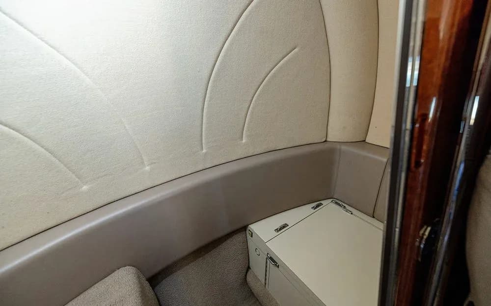 A close-up view of the beige side paneling and a small storage compartment in the aircraft's cabin.
