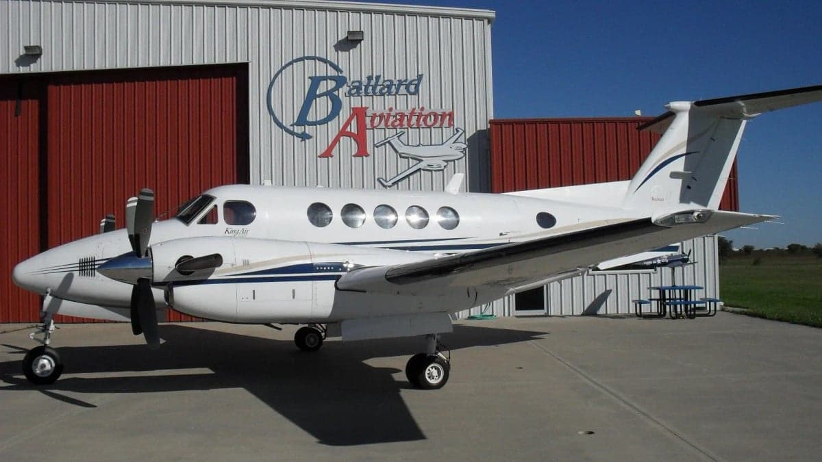 A King Air aircraft parked in front of a Ballard Aviation hangar.