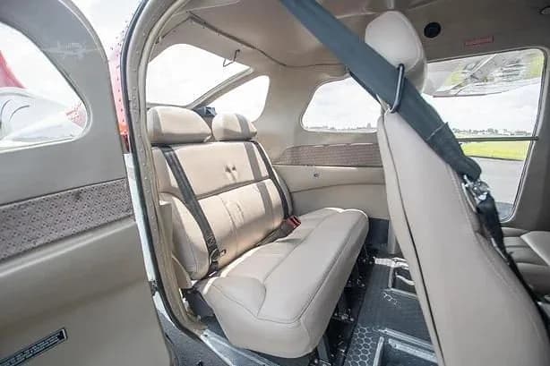 A close-up view of the light tan rear seats in the cabin of a small aircraft.