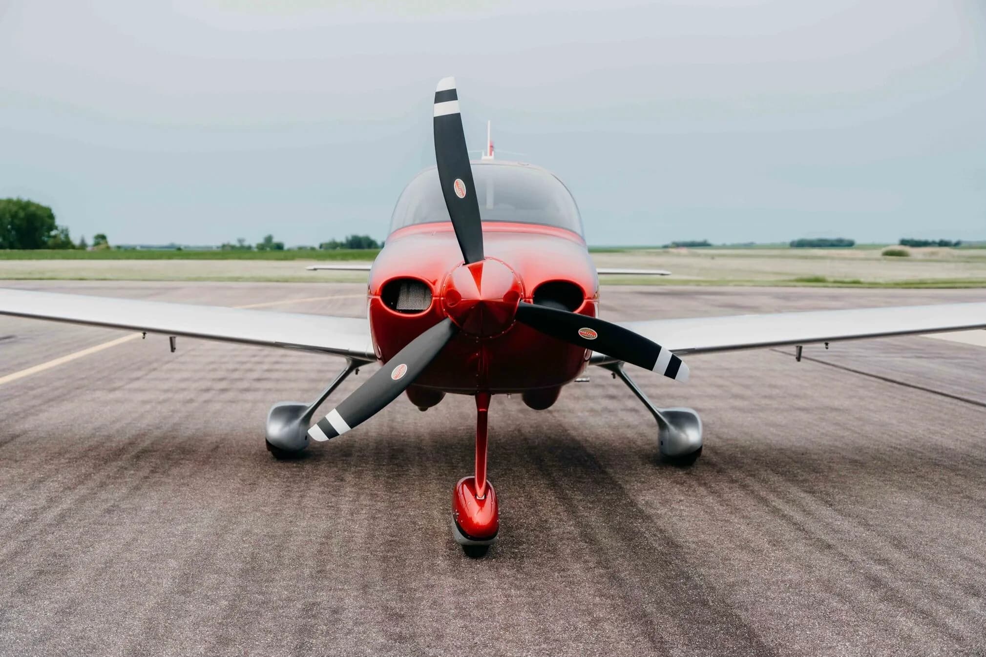 A head-on view of the red and silver Cirrus SR20 Premium aircraft (N11PS) on the tarmac.