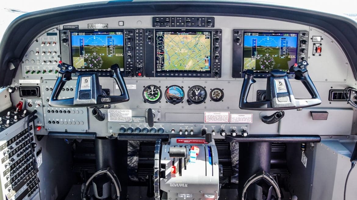 The instrument panel of a Cessna Caravan with dual screens and yokes.