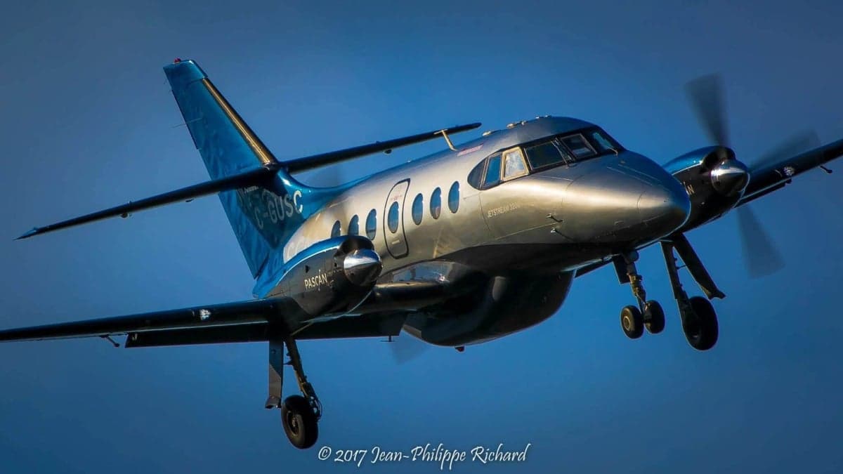 A Jetstream 3200 aircraft in flight against a blue sky.