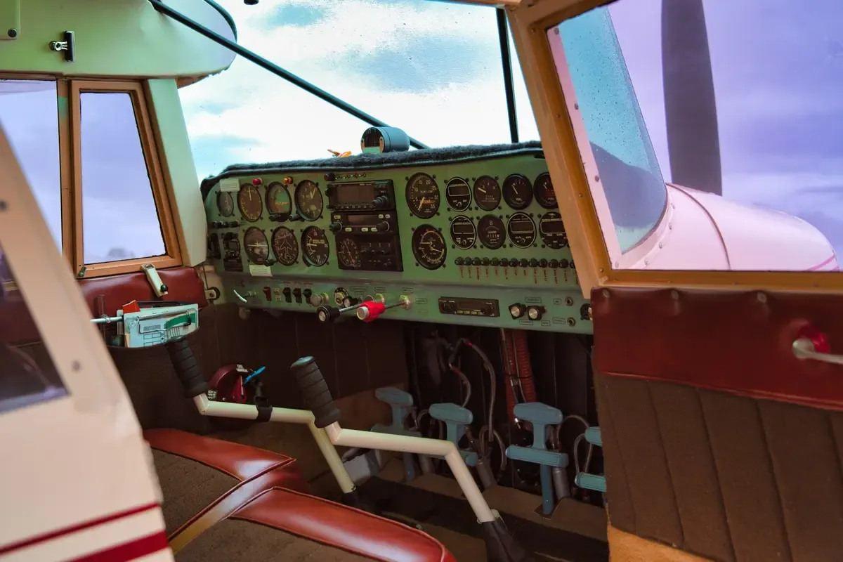 The cockpit of a small aircraft, showing the instrument panel with various gauges and controls.