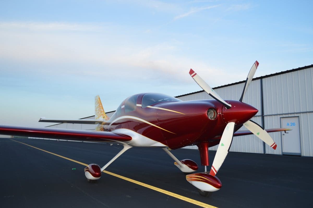Front view of the red and white aircraft with a flame design on the tail.