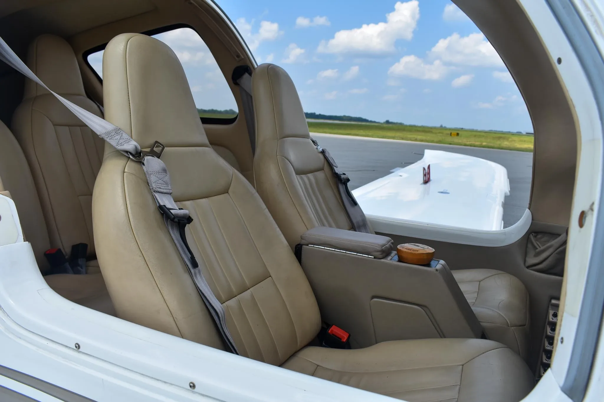 The tan leather interior cabin seats of the Columbia 400 aircraft, looking towards the rear.