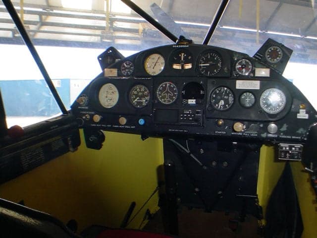 The instrument panel of the Piper Super Cub aircraft, showing various gauges and controls.