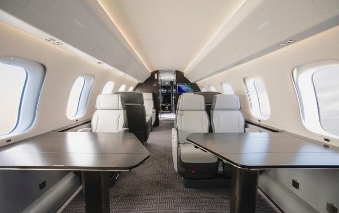 Interior of the Global 7500 cabin with a sofa, TV, and a view down the aisle.