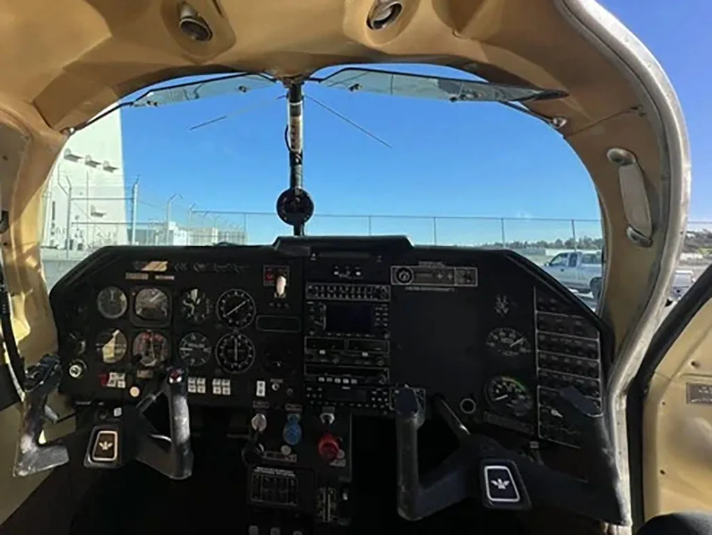 The instrument panel and dual yokes of a small aircraft cockpit, viewed from the pilot's seat.