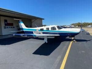 Piper Saratoga II HP aircraft with blue and white paint scheme parked on the tarmac.