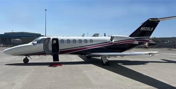 Side view of a Cessna Citation jet with an open door on the tarmac.