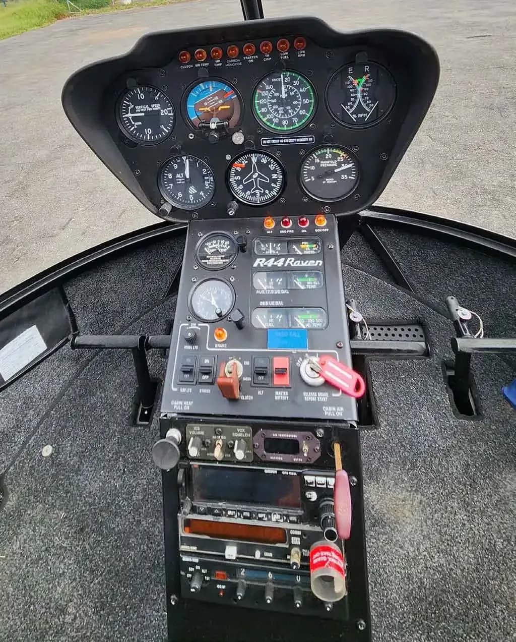 A close-up view of the instrument panel and avionics stack in a Robinson R44 Raven helicopter.