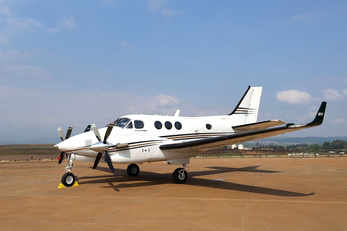 A King Air aircraft is parked on the tarmac on a sunny day.