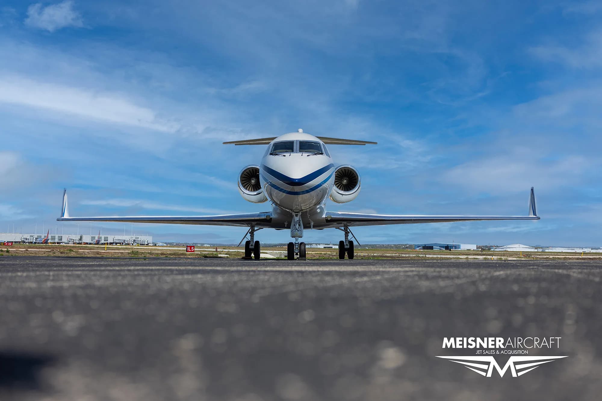 Front view of a Gulfstream G550 aircraft with blue and white paint scheme.