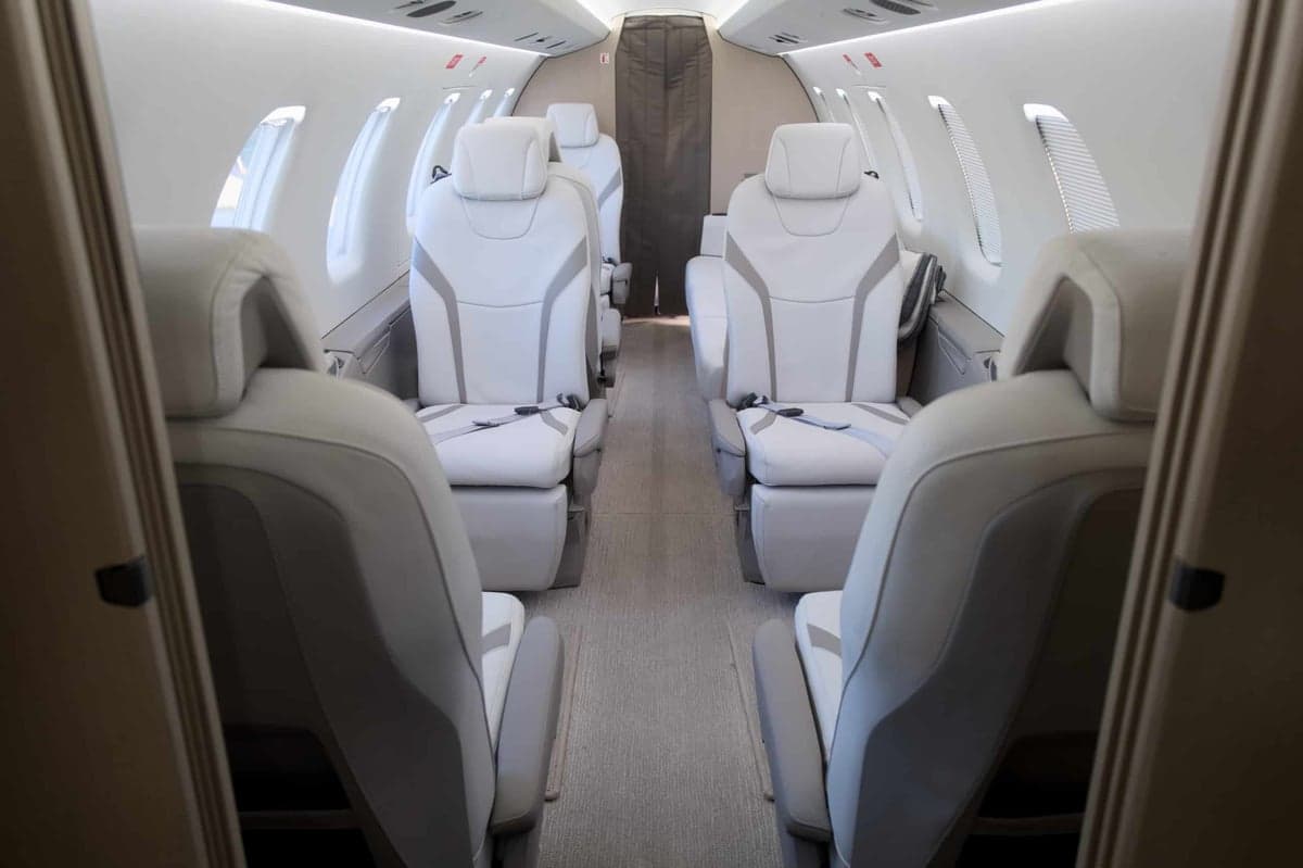 View of the aircraft's interior cabin with white leather seats.
