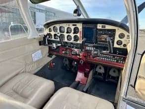 The cockpit of a Piper PA-28 Cherokee, showing the instrument panel and front seats.