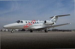 A white jet aircraft with black stripes is parked on the tarmac with the word SOLD overlaid.