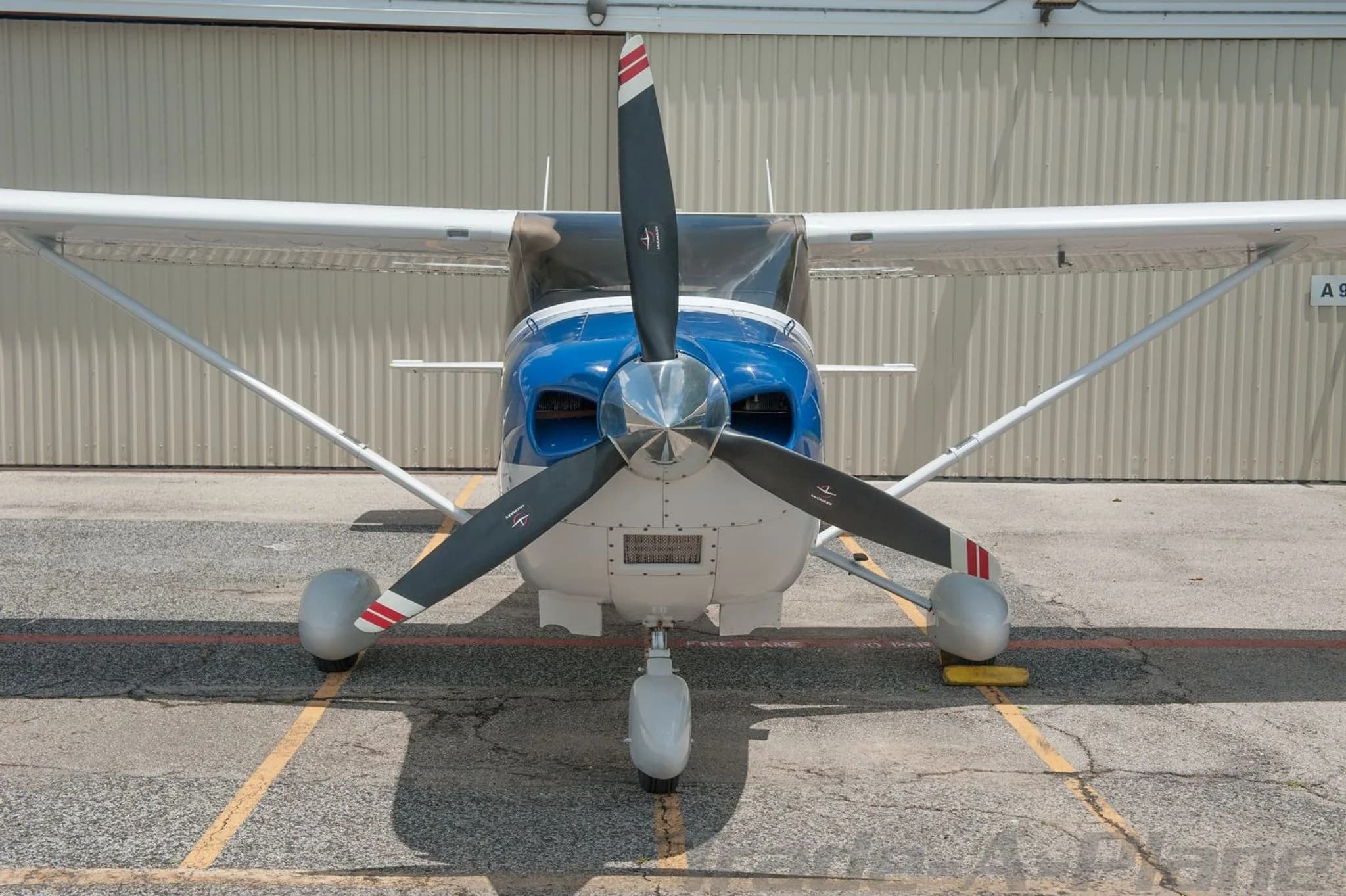 A head-on view of a white and blue Cessna Skylane N65862 with its propeller centered.