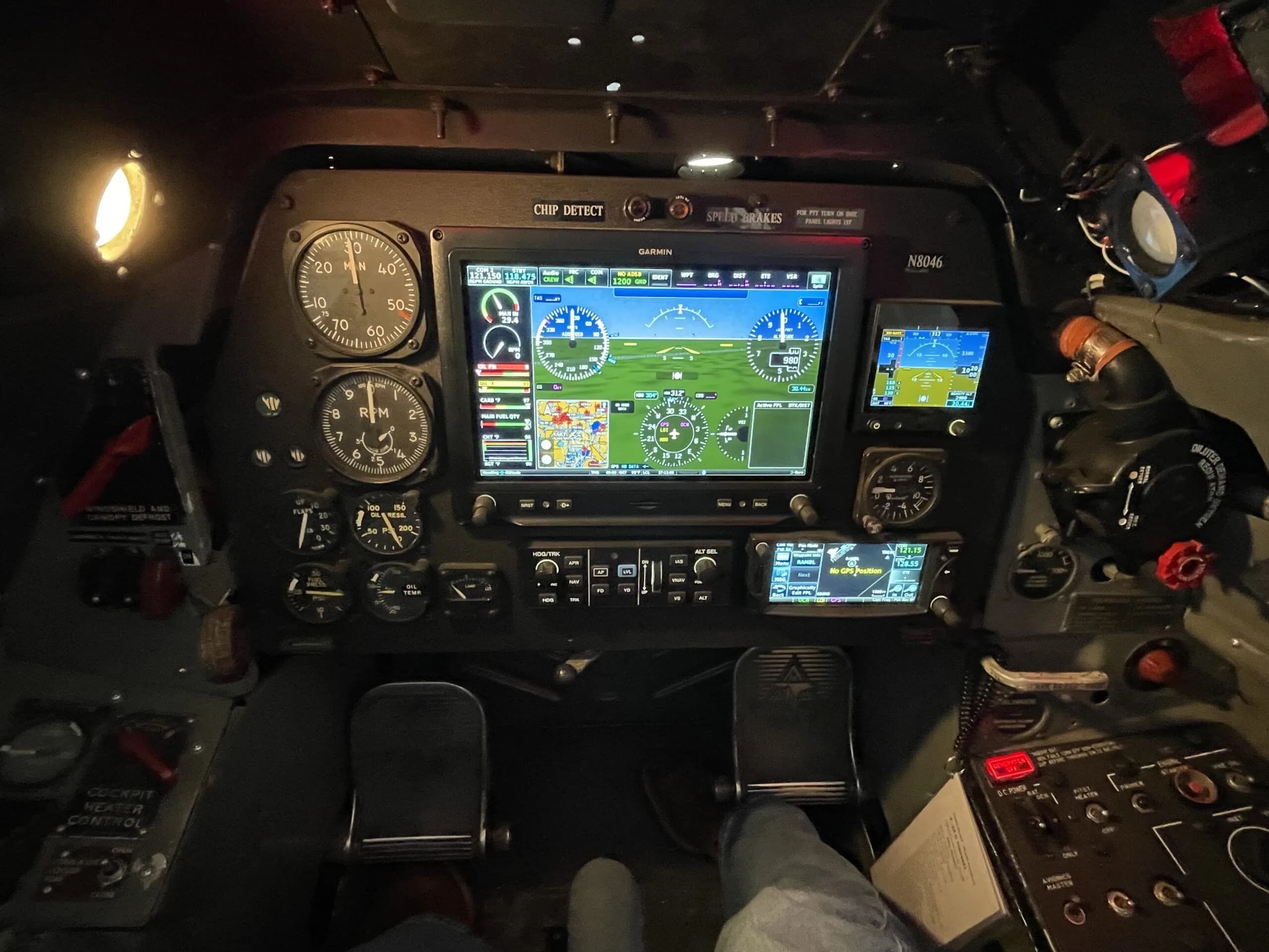 A close-up view of the T-28 Trojan's instrument panel, highlighting the large central Garmin display and surrounding analog gauges.