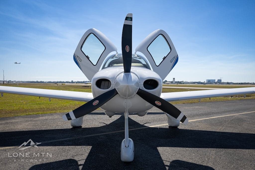 Front view of Cirrus SR22T aircraft N232NE with open doors on the tarmac.