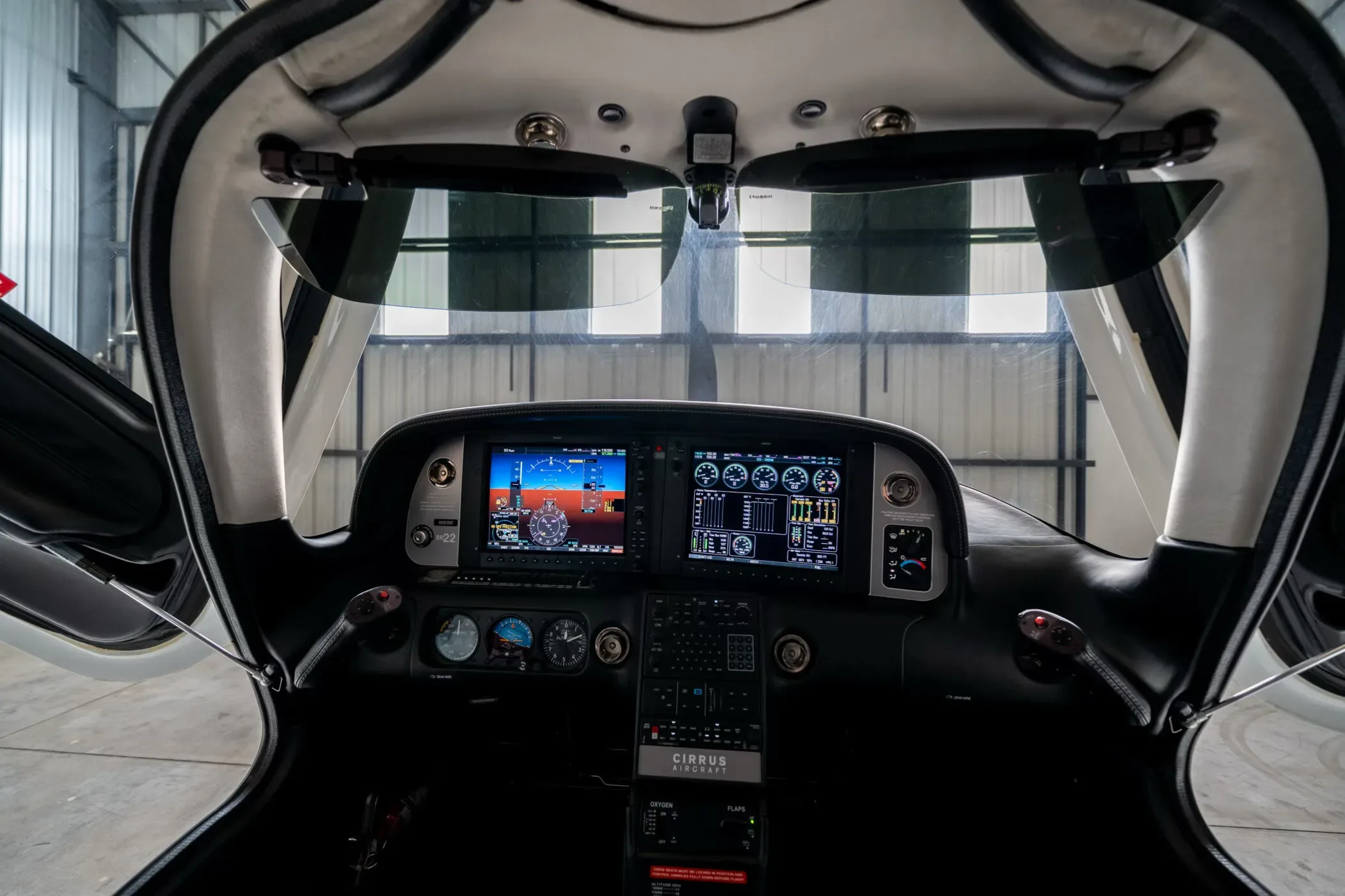 A wide-angle view of the Cirrus SR22 aircraft's glass cockpit, featuring dual display screens.