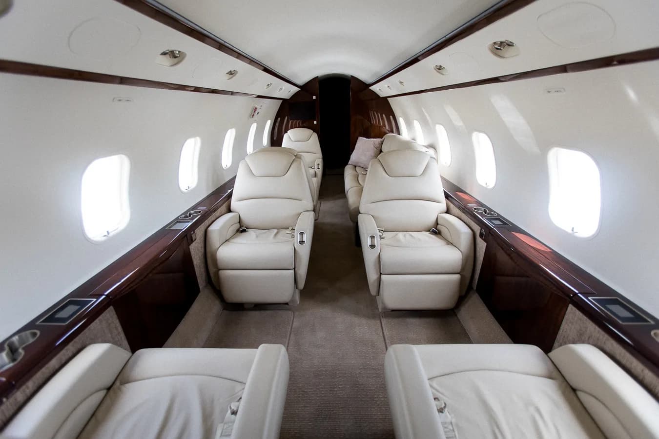 View of the aircraft interior with leather seats and wood trim.