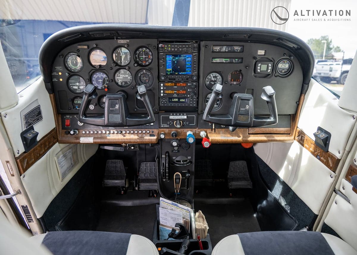 The cockpit of a Cessna aircraft, featuring a full instrument panel and dual control yokes.