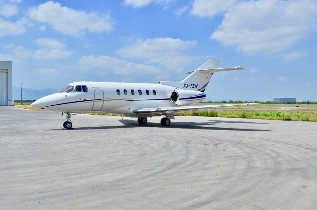 XA-TEM aircraft parked on the tarmac with a hangar in the background.