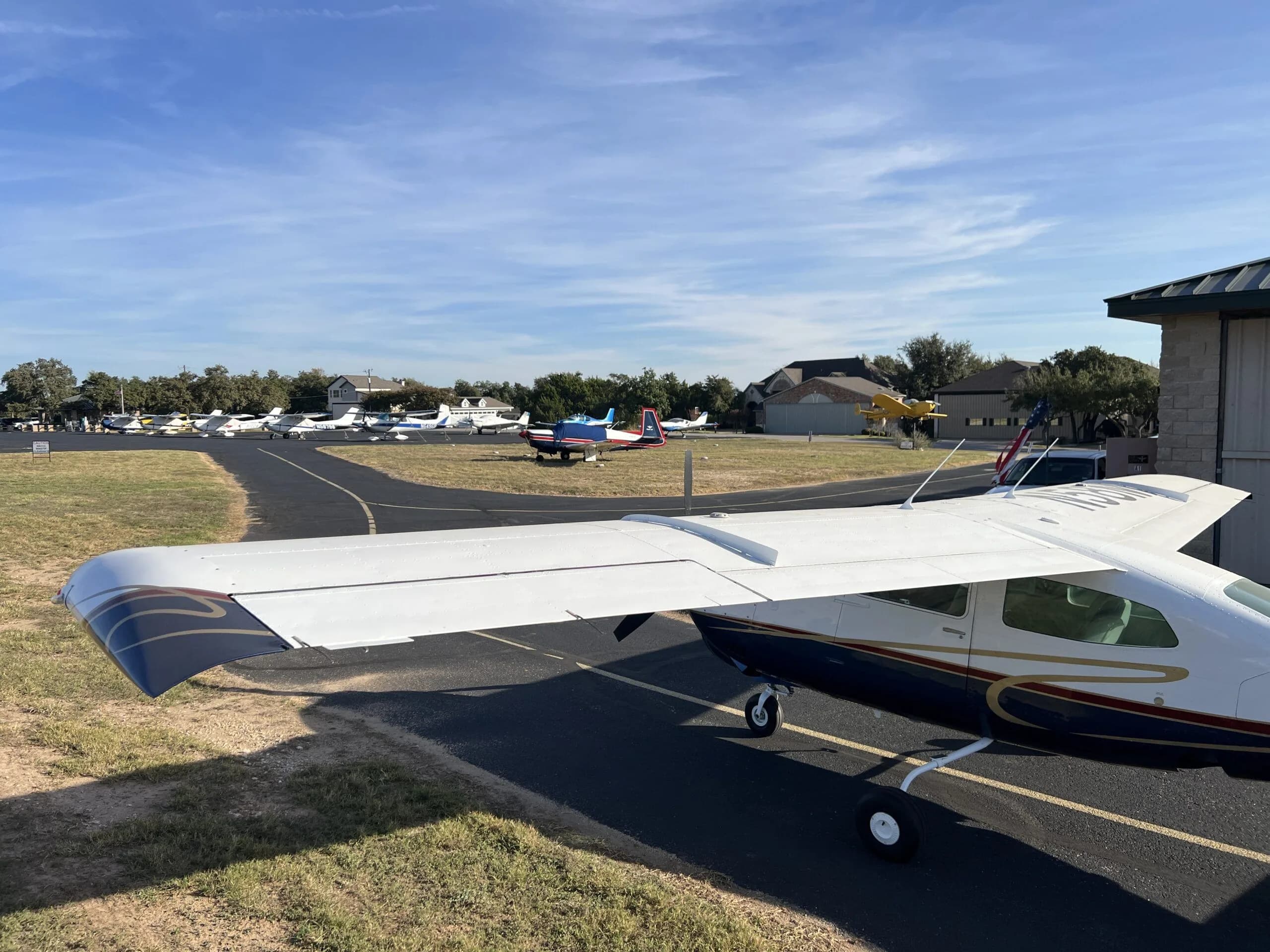 A rear view of the Cessna 210, N58MA, on a taxiway with other aircraft parked in the distance.