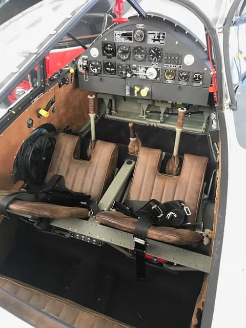 View of the aircraft cockpit with brown seats and instrument panel.