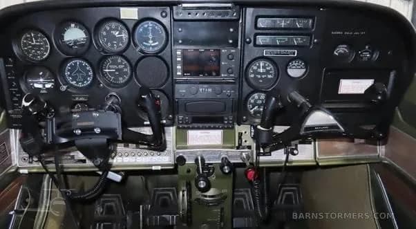 The full instrument panel of a Cessna 172, showing gauges, radios, and control yokes.
