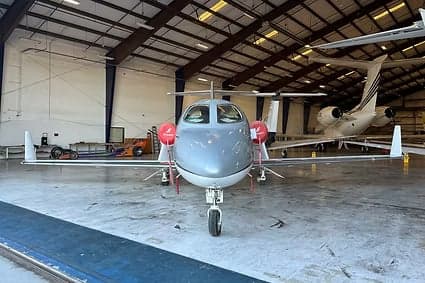 Front view of a HondaJet inside a hangar.