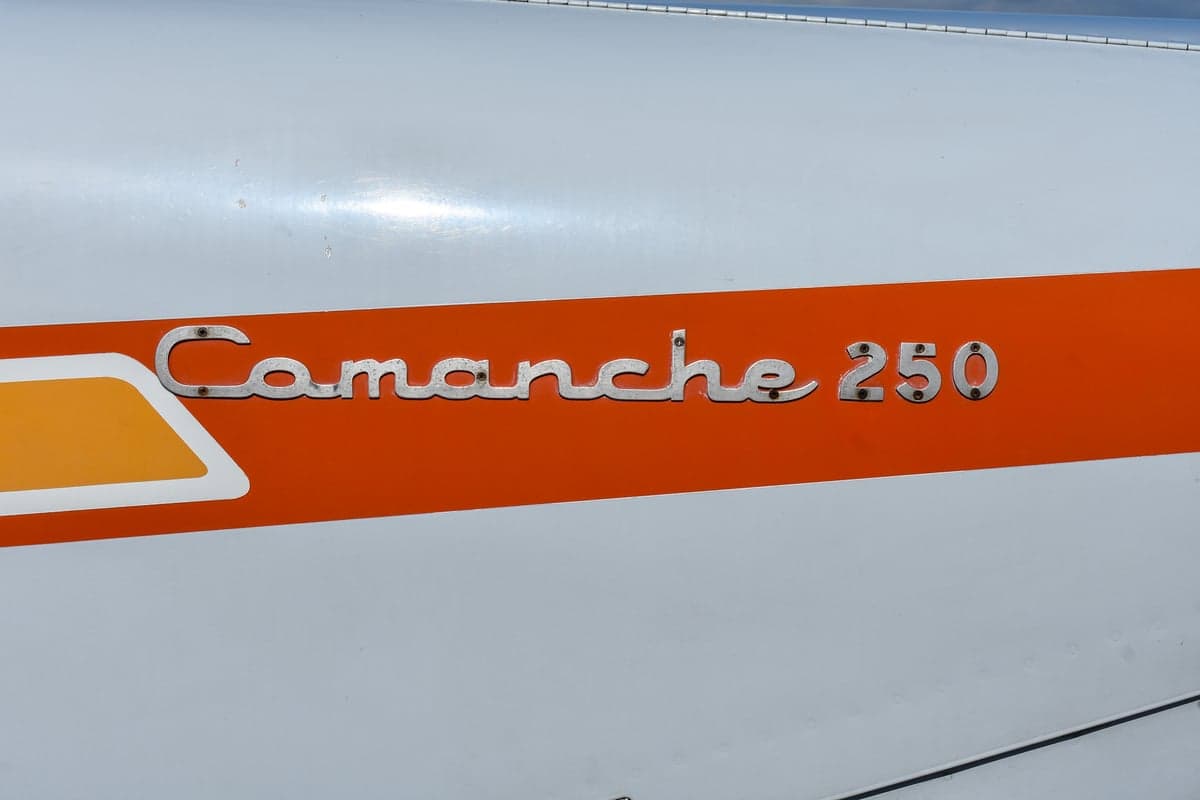 Piper Comanche 250 aircraft, front quarter view, on the tarmac.